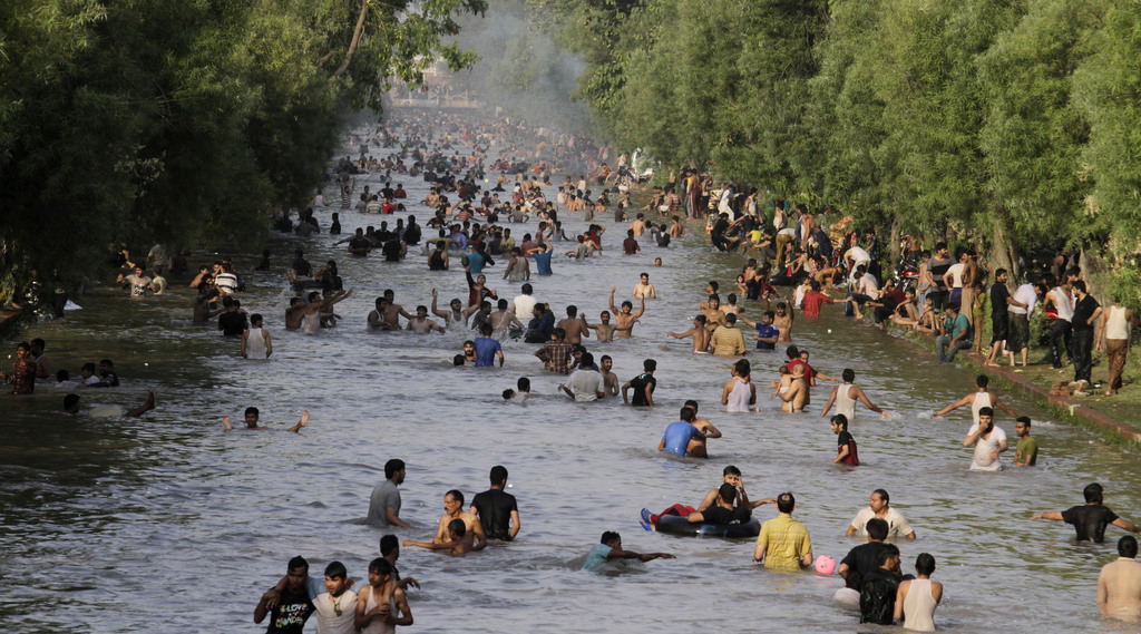 Des gens se refroidissent dans un canal de Lahore au Pakistan le 7 juin 2015